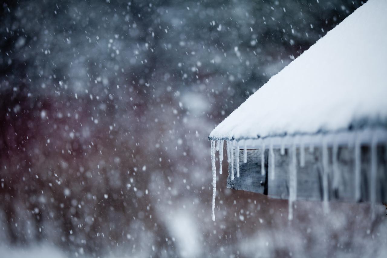 Closeup of icicles on a roof during a snowstorm