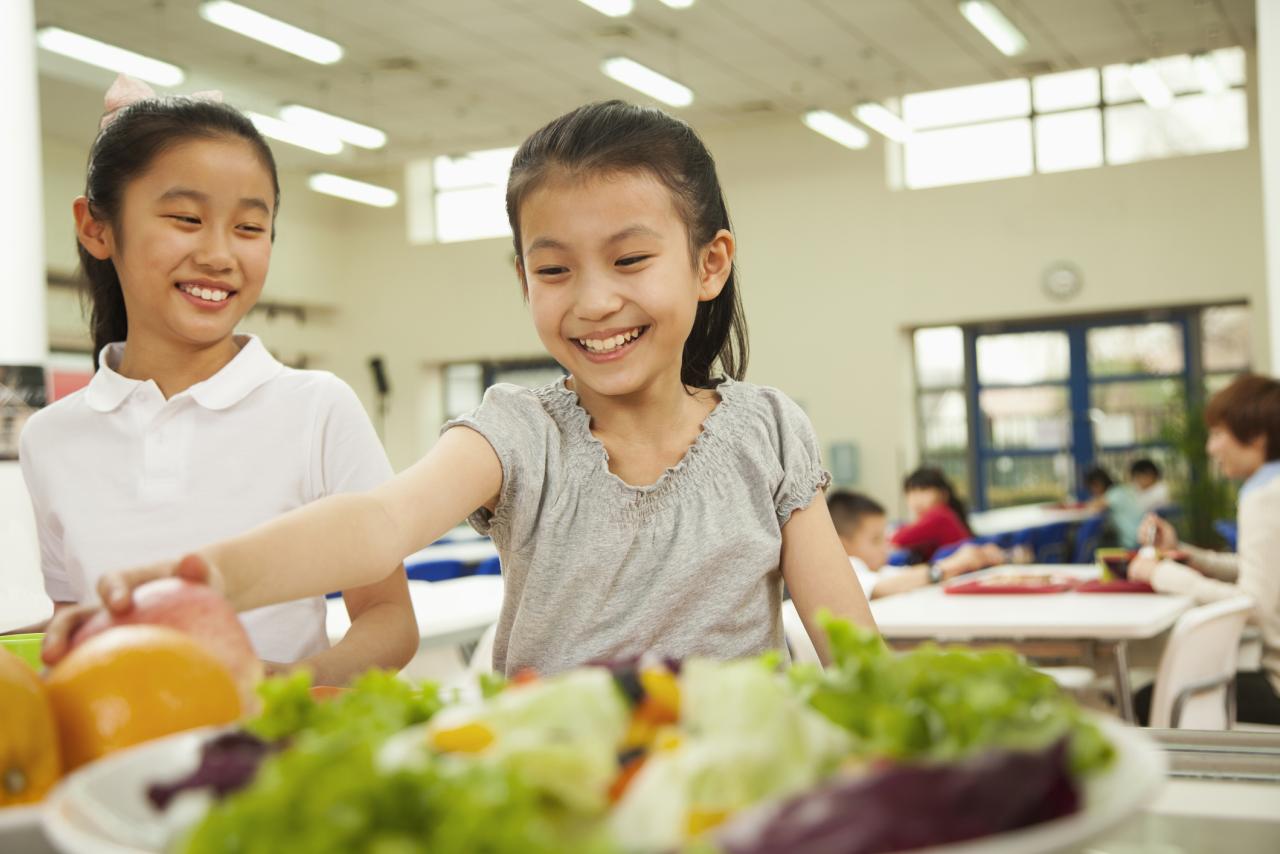 Two children picking out lunch in a cafeteria