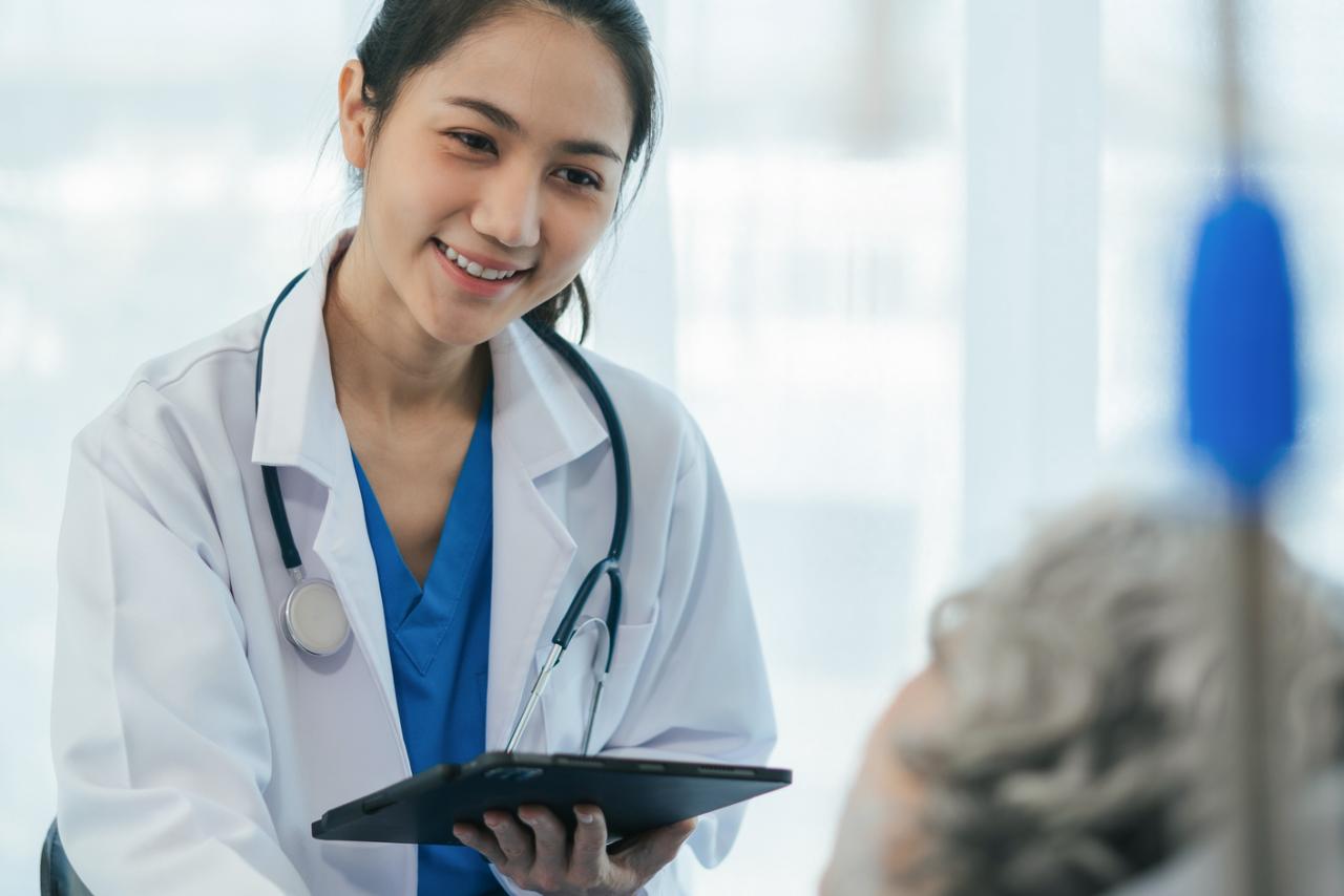 Doctor giving patient information while they lay in a hospital bed