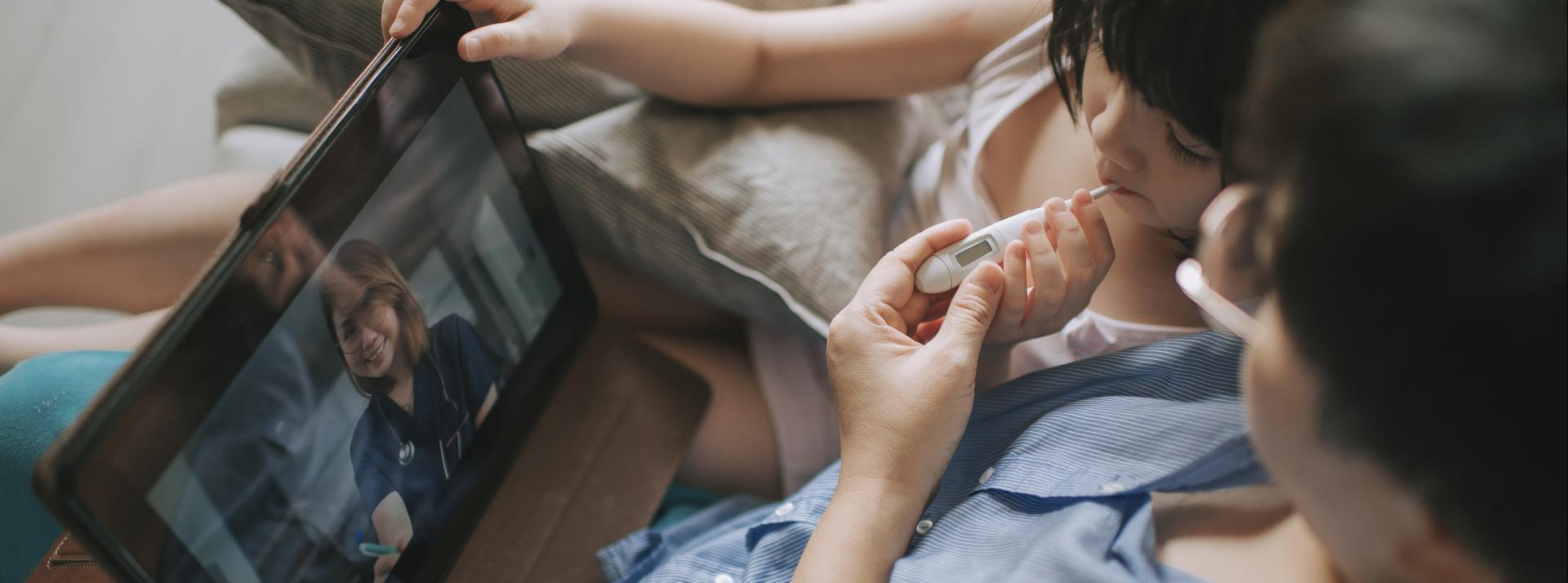 A person with their child talking with a doctor on a tablet
