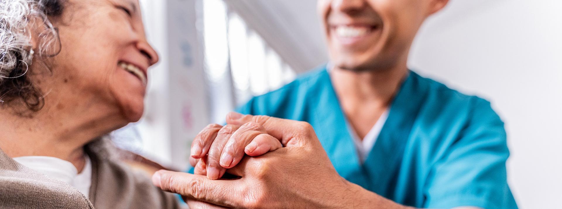 Senior woman holding caregiver's hands