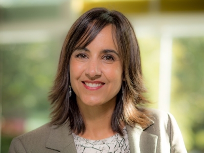 A portrait of Darcia Pope indoors.  She is wearing a white shirt and grey blazer