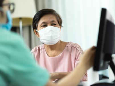 woman talking to nurse looking at computer screen