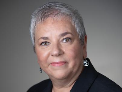 A portrait of Vivian Eliopoulos in front of a grey background